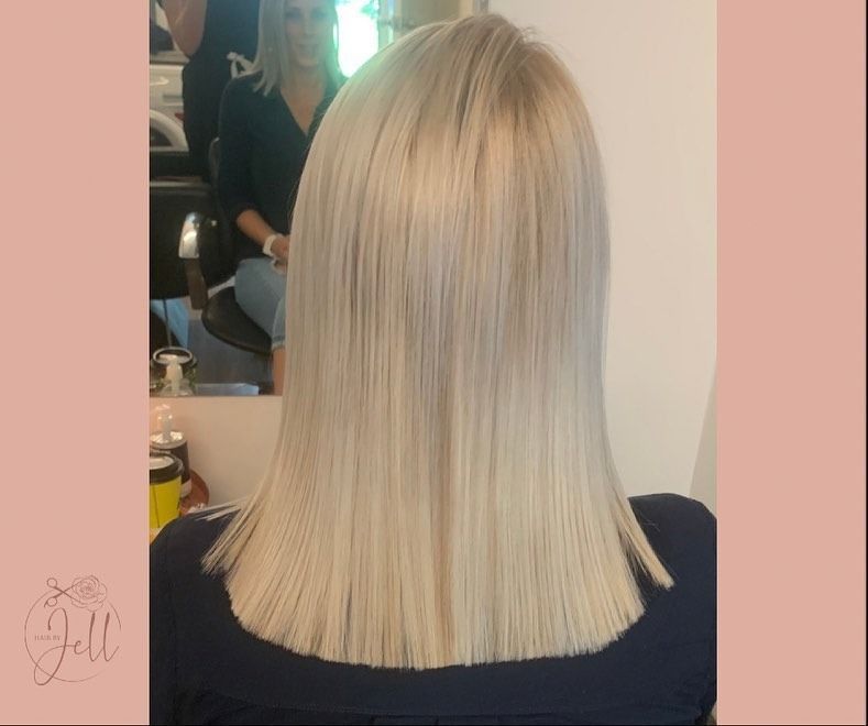 A Woman With Blonde Hair is Sitting in Front of a Mirror — Hair By Jell In Cannonvale, QLD