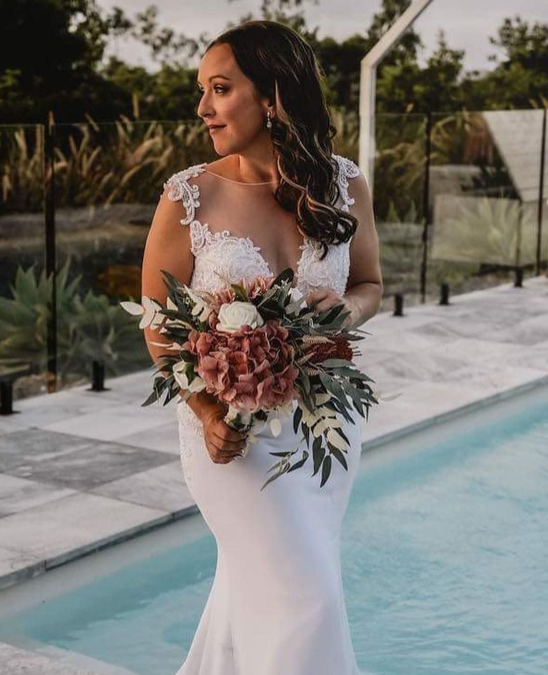 A Woman In A Wedding Dress Holding A Bouquet Of Flowers – Hair By Jell In Cannonvale, QLD