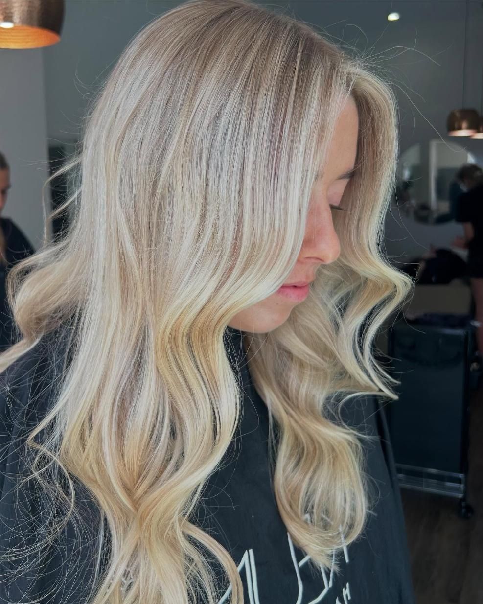 A Woman With Long Blonde Hair is Standing in a Salon — Hair By Jell In Cannonvale, QLD