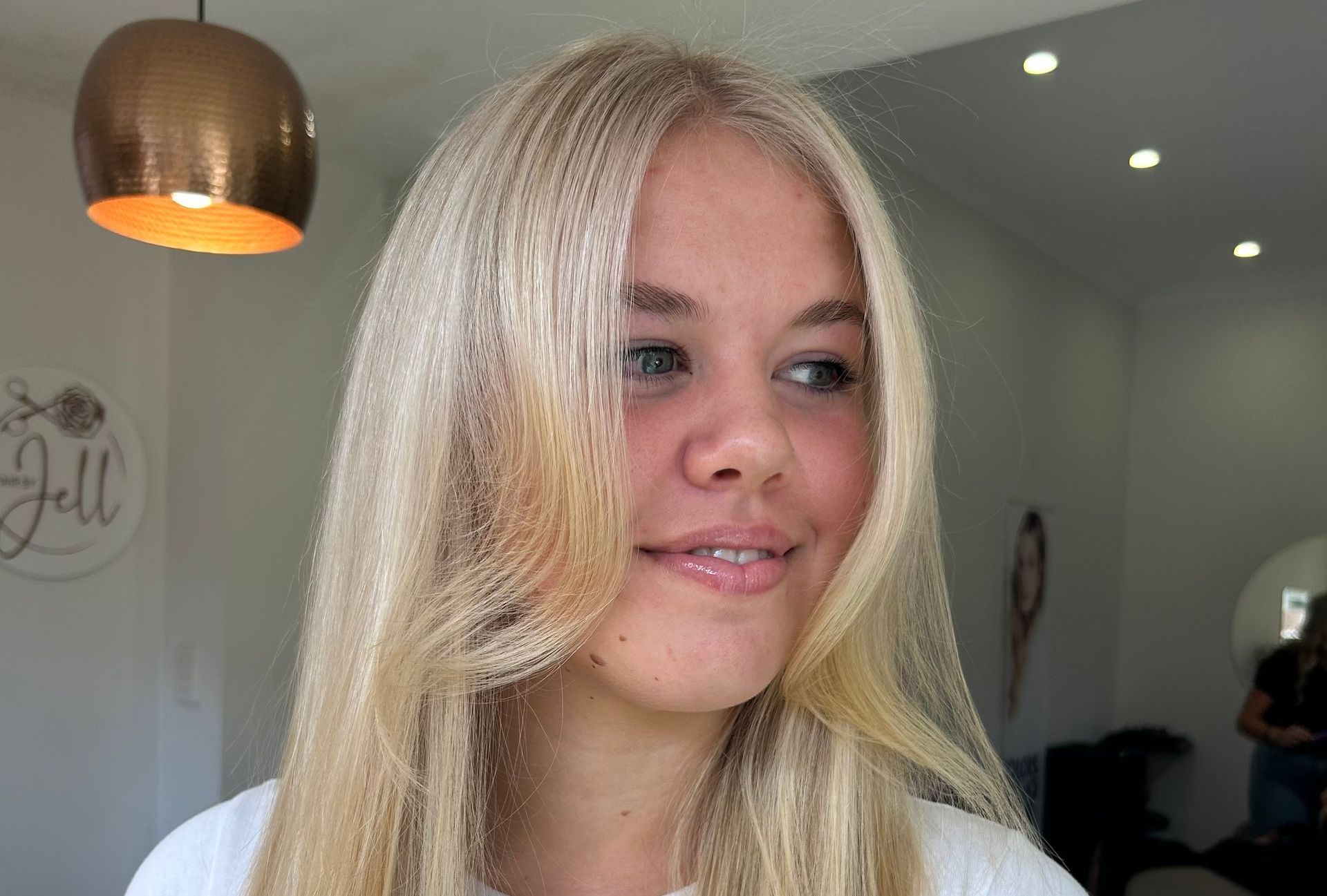 A Woman Wearing a Gold Dress and Earrings is Smiling — Hair By Jell In Cannonvale, QLD