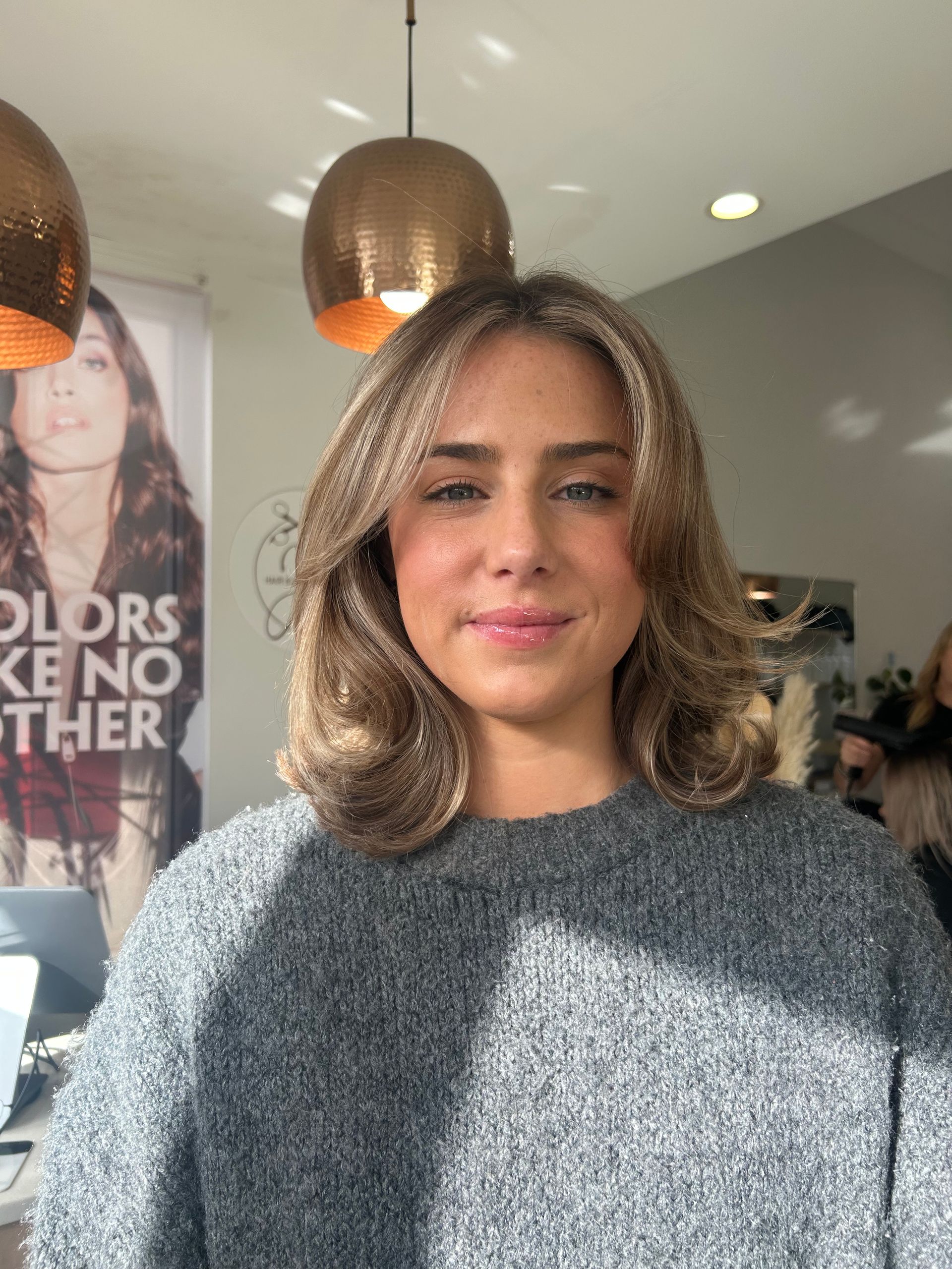 A Woman With Long Brown Hair is Sitting in a Salon — Hair By Jell In Cannonvale, QLD