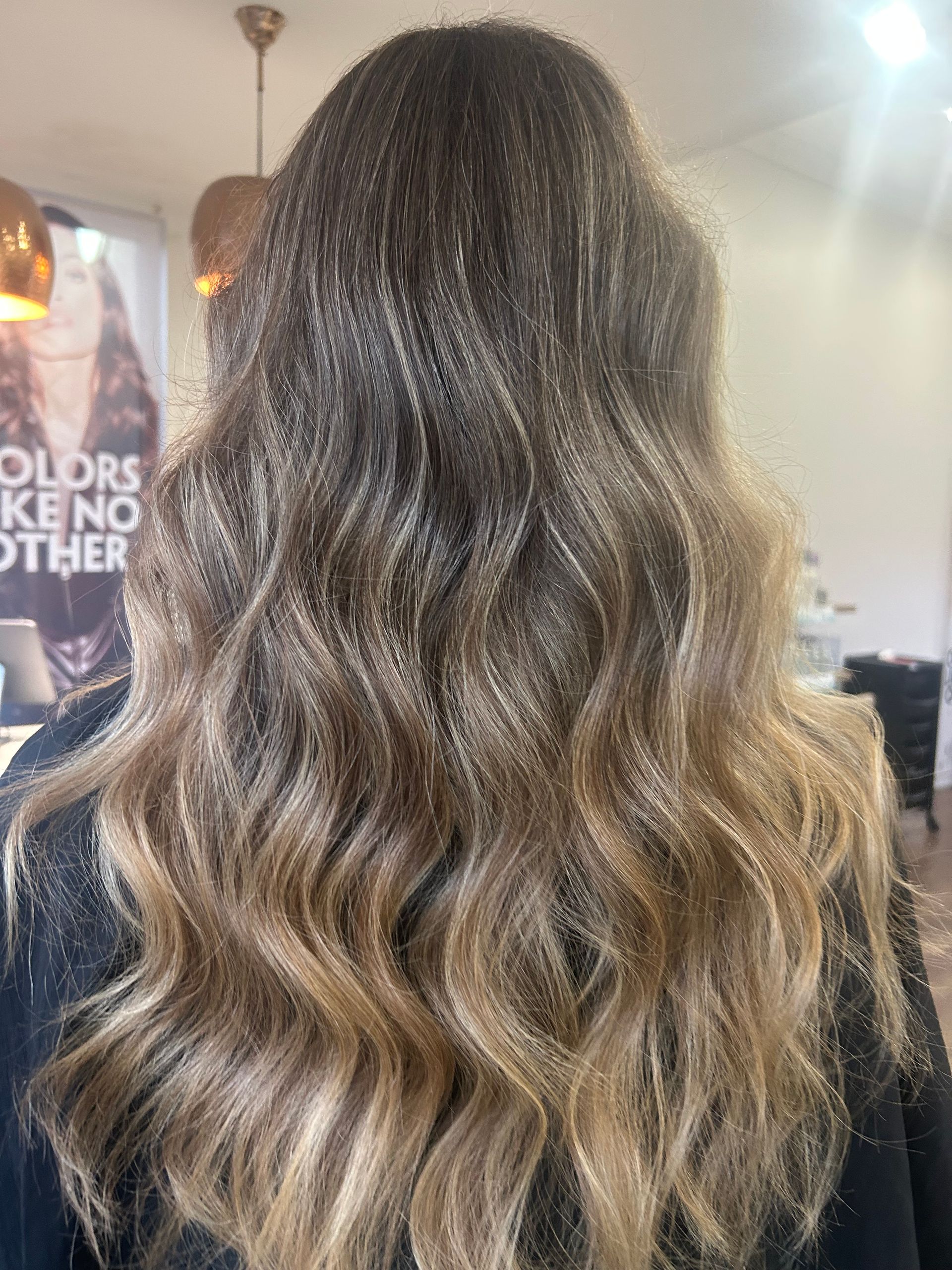 A Woman With Long Brown Hair is Sitting in a Salon — Hair By Jell In Cannonvale, QLD