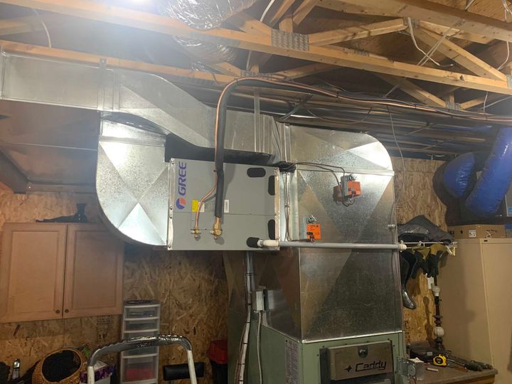 Installation d'un système de chauffage, ventilation et climatisation dans un sous-sol, avec conduits, tuyauterie et raccords.