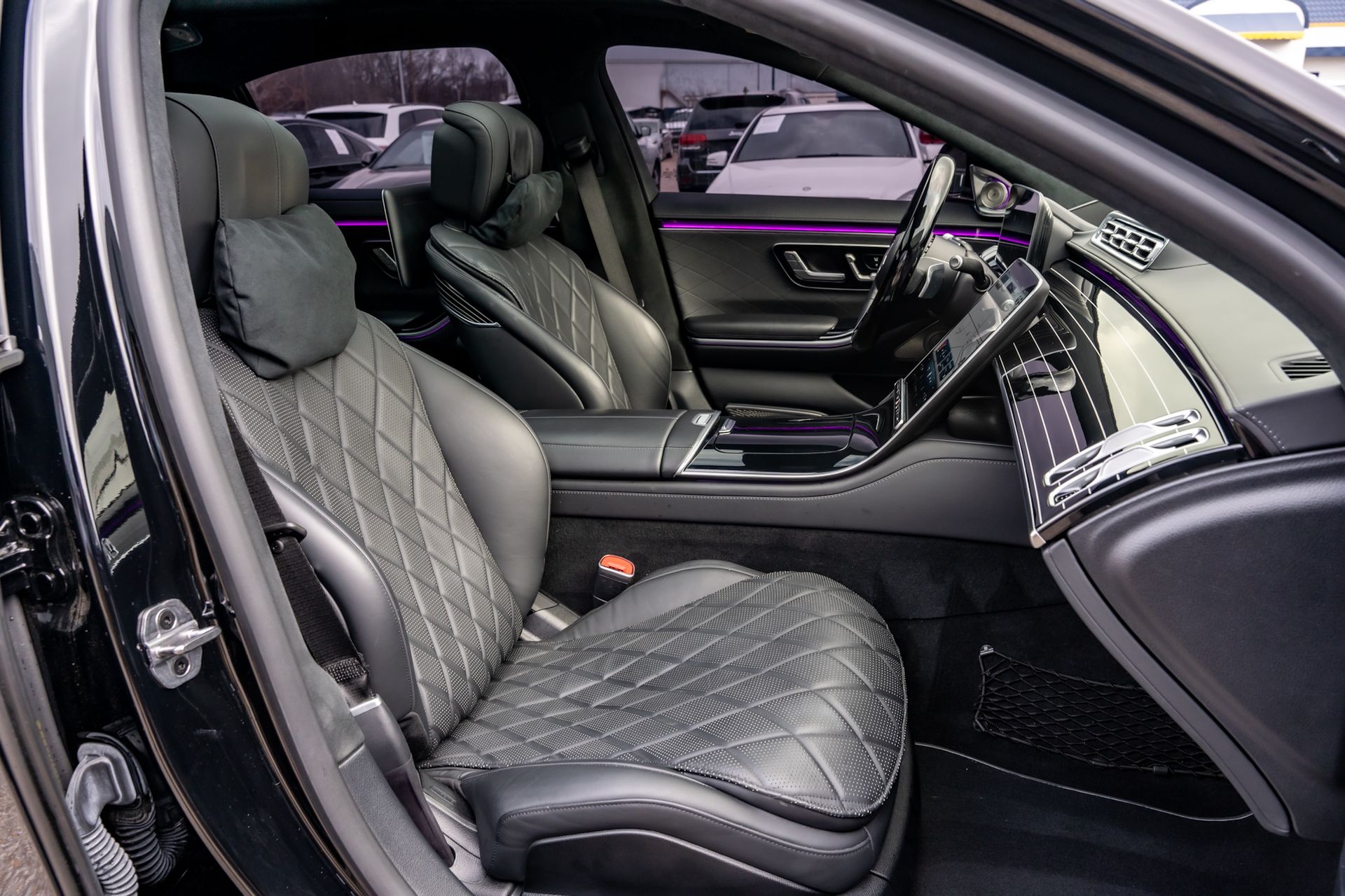 Black leather interior of a luxury car; front seats, dashboard, steering wheel visible.