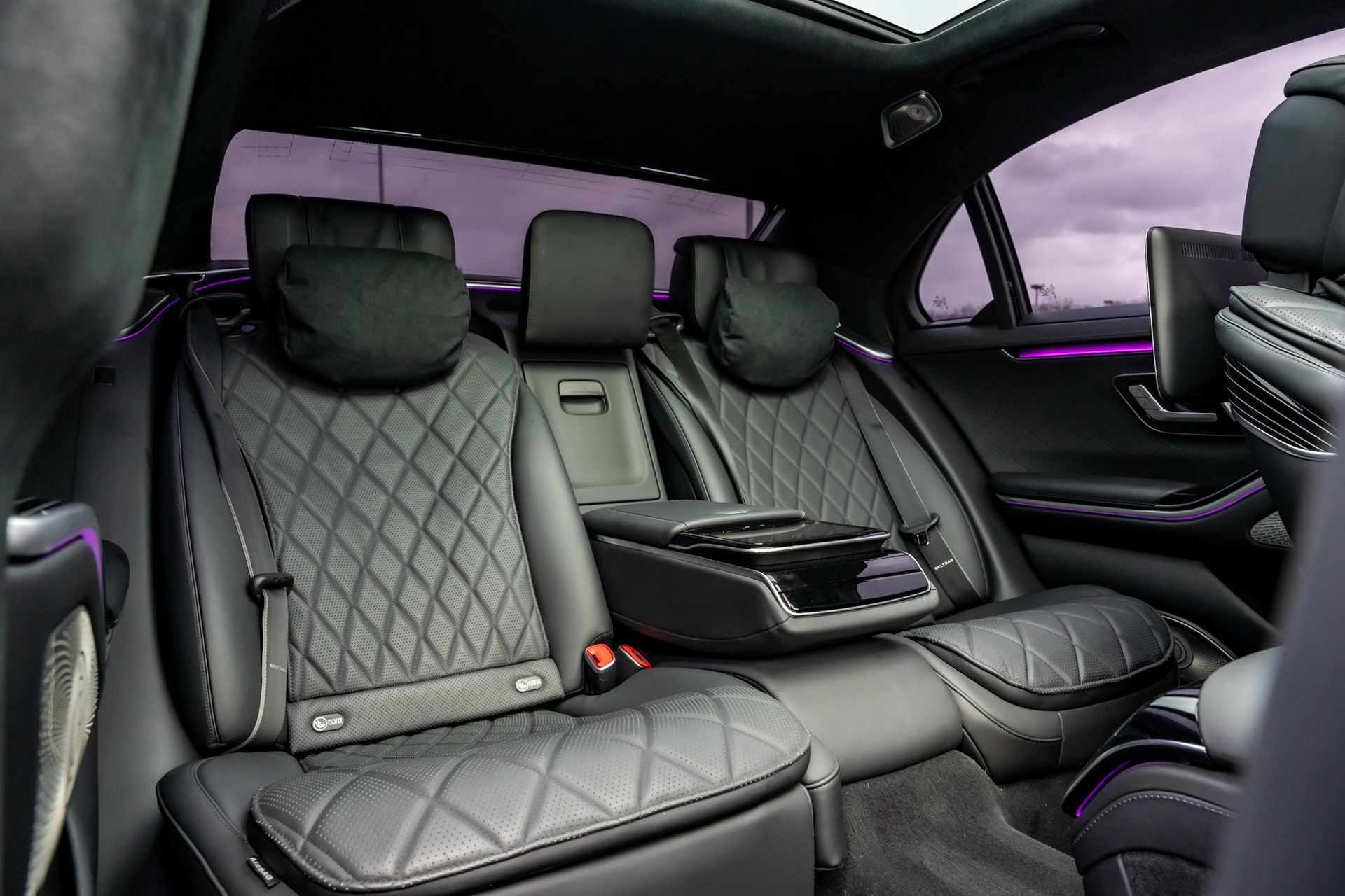 Black leather interior of a luxury car with quilted seats and center console.