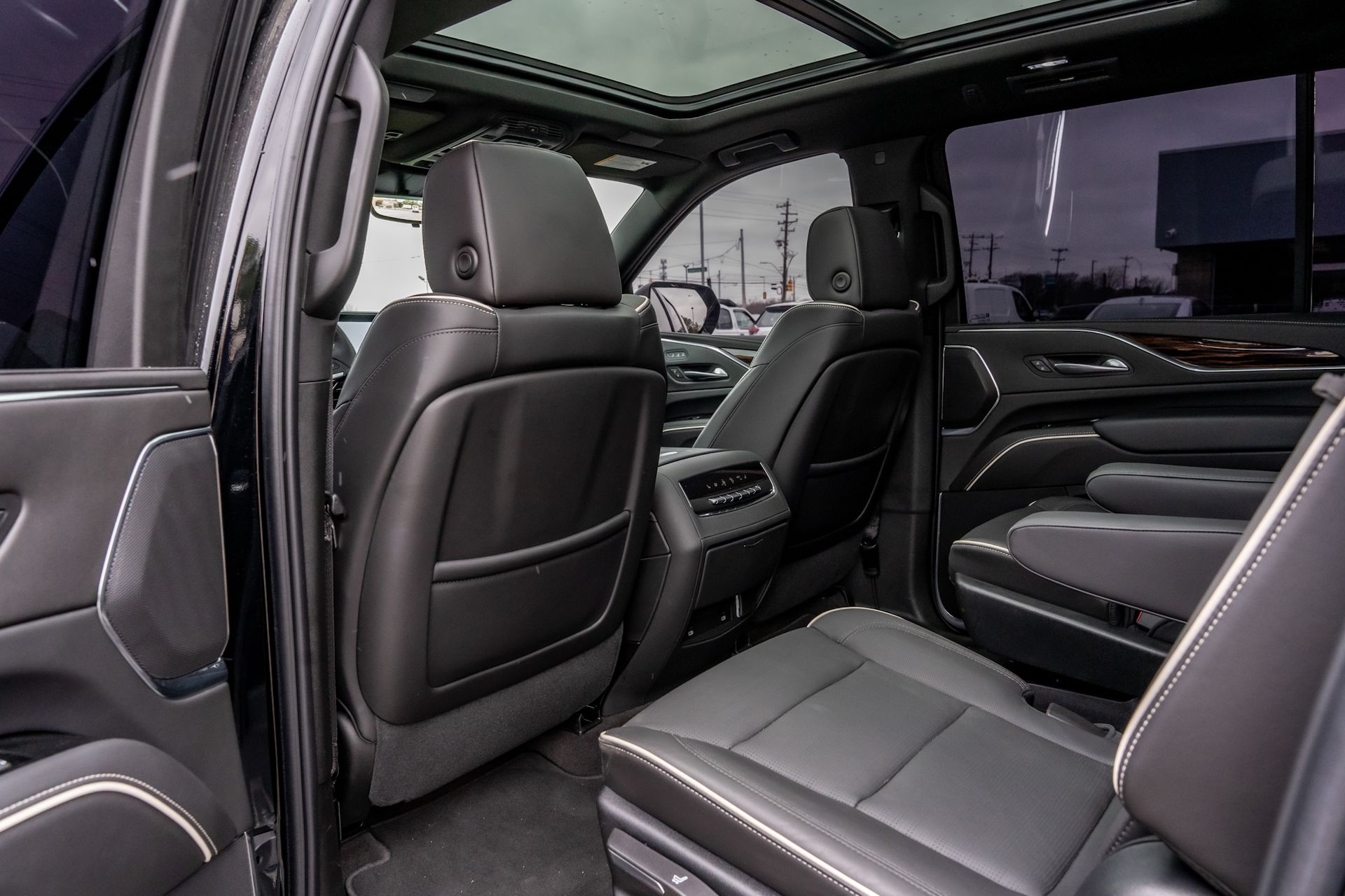 Black leather car interior with a panoramic sunroof and rear seats visible.