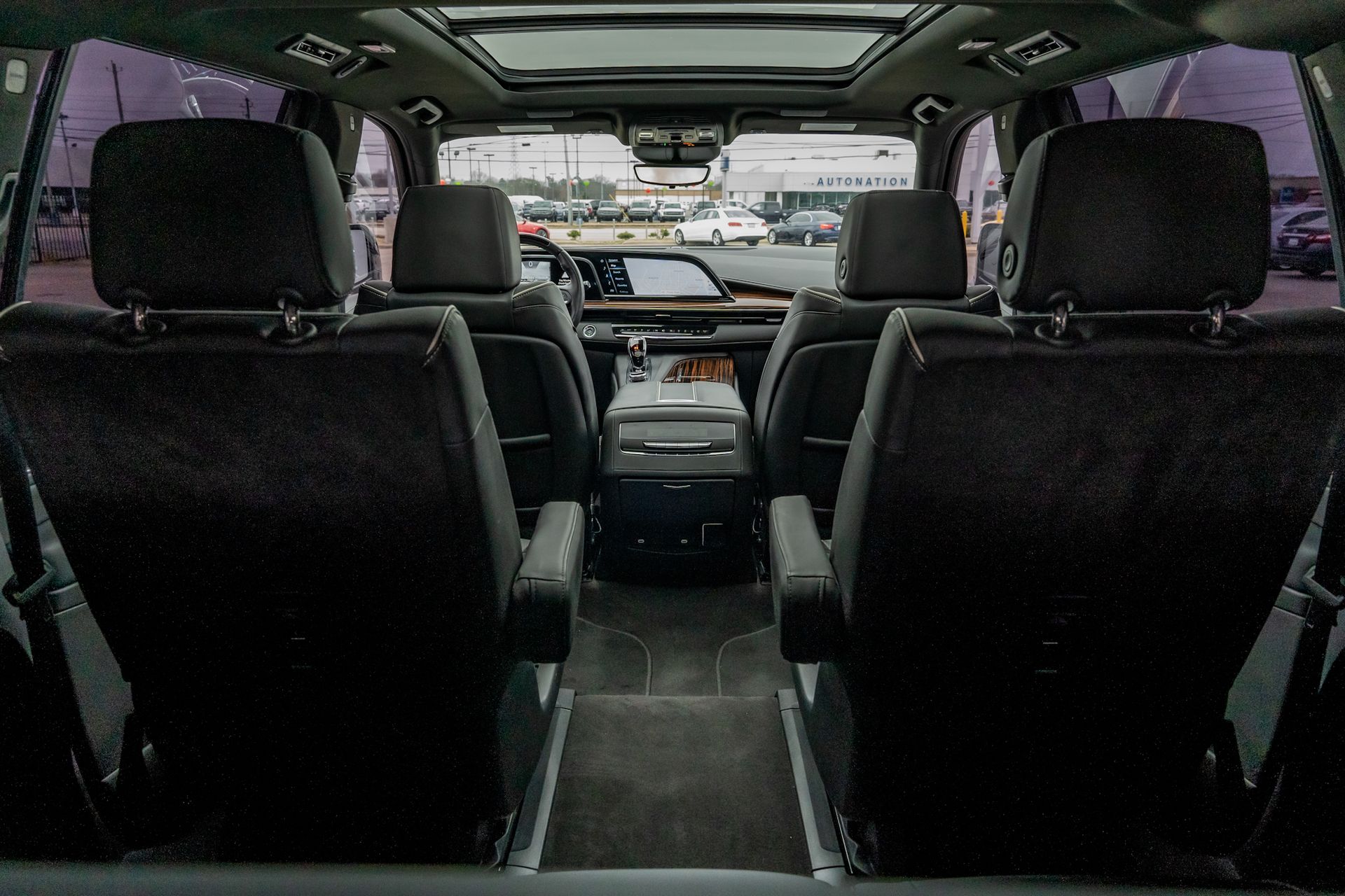 Interior of a black SUV with two rows of seats, center console, and sunroof.