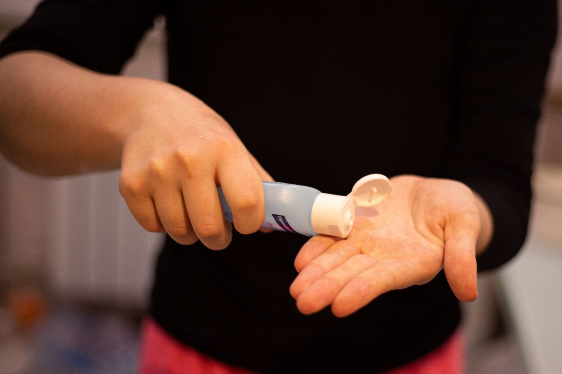 woman pouring out hand sanitizer onto hand