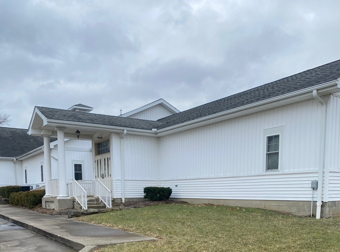 Exterior view of Courtney Real Estate office building, which is a one story white building.