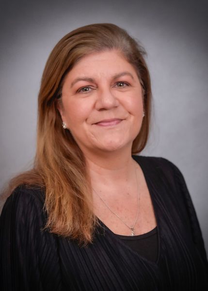 A woman in a black shirt is smiling for the camera.