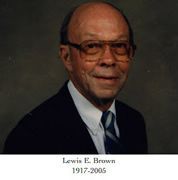 A bald man wearing glasses and a suit and tie is smiling for the camera.