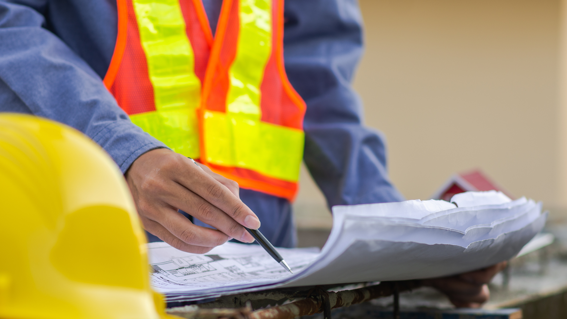 A construction worker is writing on a piece of paper with a pen.