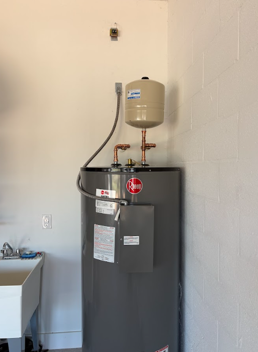 Water heater and expansion tank in a utility room against a white wall.