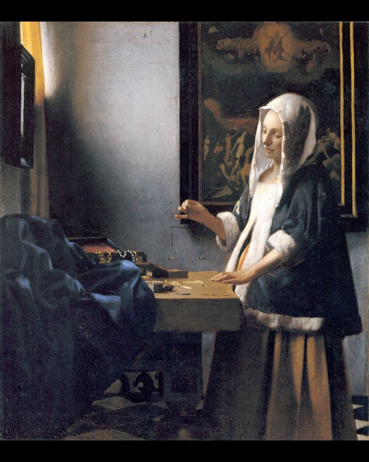 Vrouw met witte muts en blauwe jas, aan een tafel met sieraden, interieur, schilderij aan de muur.