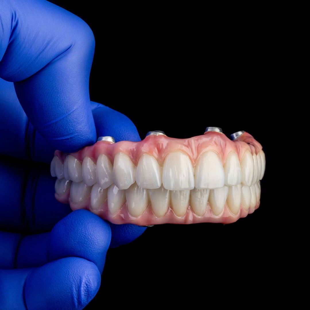 gloved-hand-holding-set-of-teeth