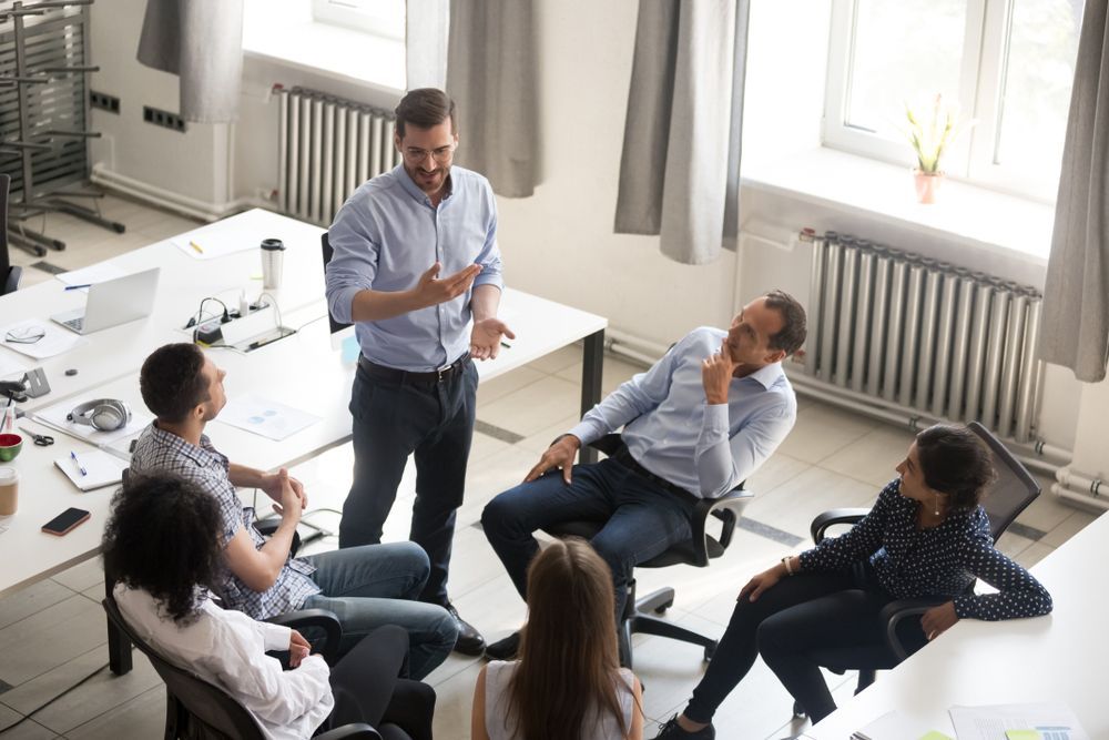 Business Team in a Circle, Listening to a Man Speaking — People Assured Partners in Cannonvale, QLD