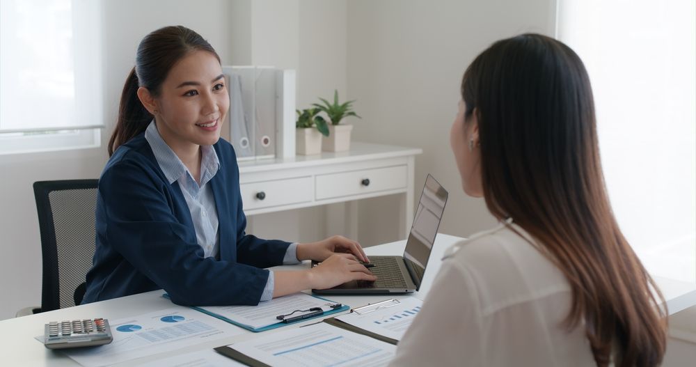 Woman in Navy Blazer Having Meeting With Another Woman in an Office — People Assured Partners in Mackay, QLD
