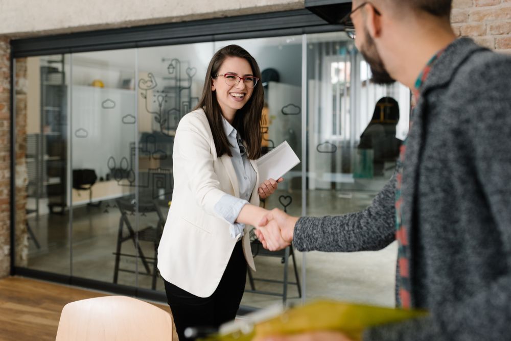 Woman in Glasses Shakes Hands With a Man — People Assured Partners in Bowen, QLD