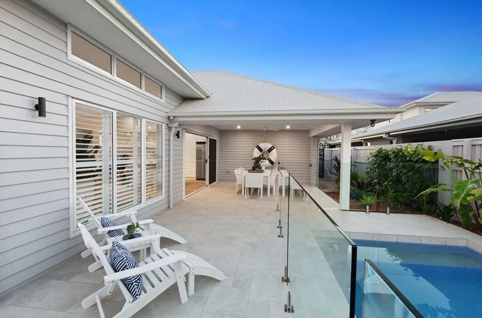 There Is A Swimming Pool In The Backyard Of A House — Norm Evans Floors Pty Ltd in Kunda Park, QLD