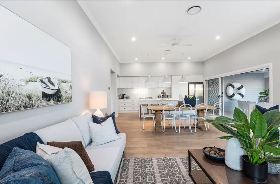 A Living Room With A Couch , Table , Chairs And A Painting On The Wall — Norm Evans Floors Pty Ltd in Kunda Park, QLD