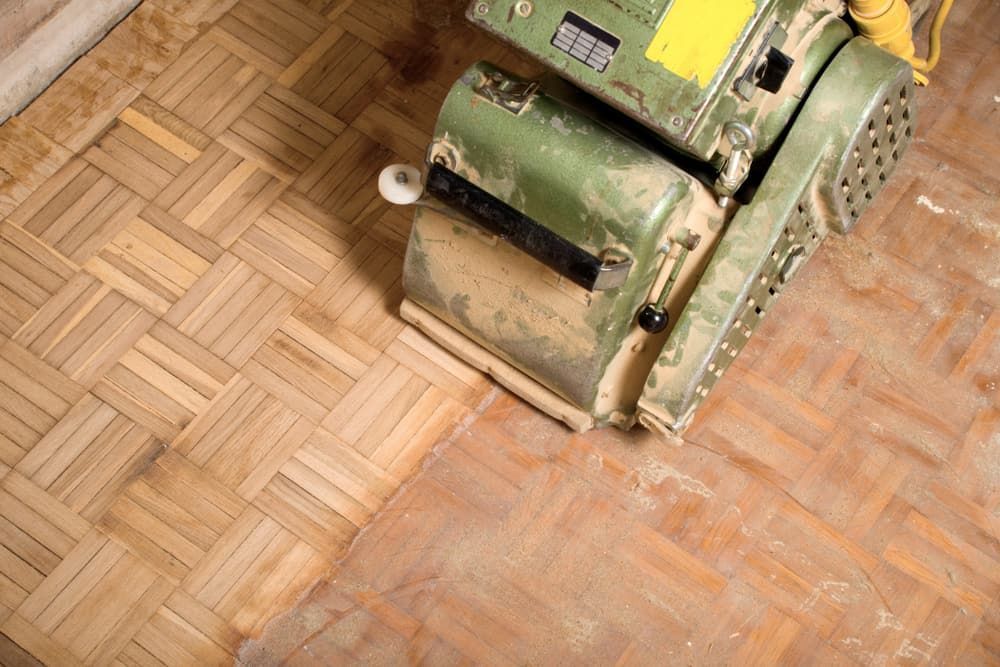 A Machine Is Sanding A Wooden Floor  — Norm Evans Floors Pty Ltd in Kunda Park, QLD