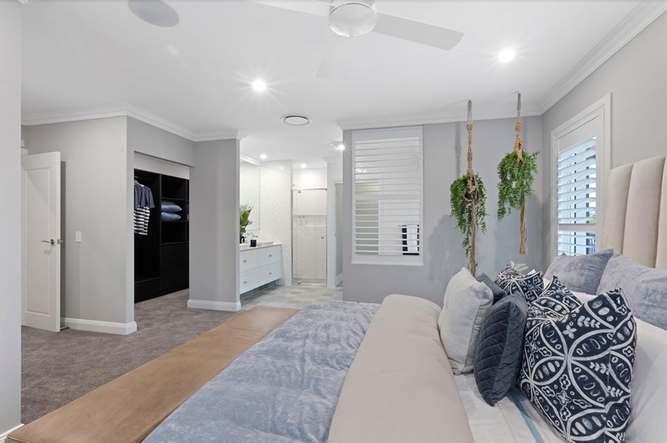 A Bedroom With A Large Bed And A Ceiling Fan — Norm Evans Floors Pty Ltd in Kunda Park, QLD