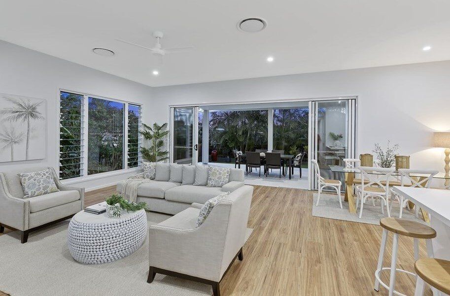 A Living Room With A Couch , Chairs , And A Table — Norm Evans Floors Pty Ltd in Kunda Park, QLD