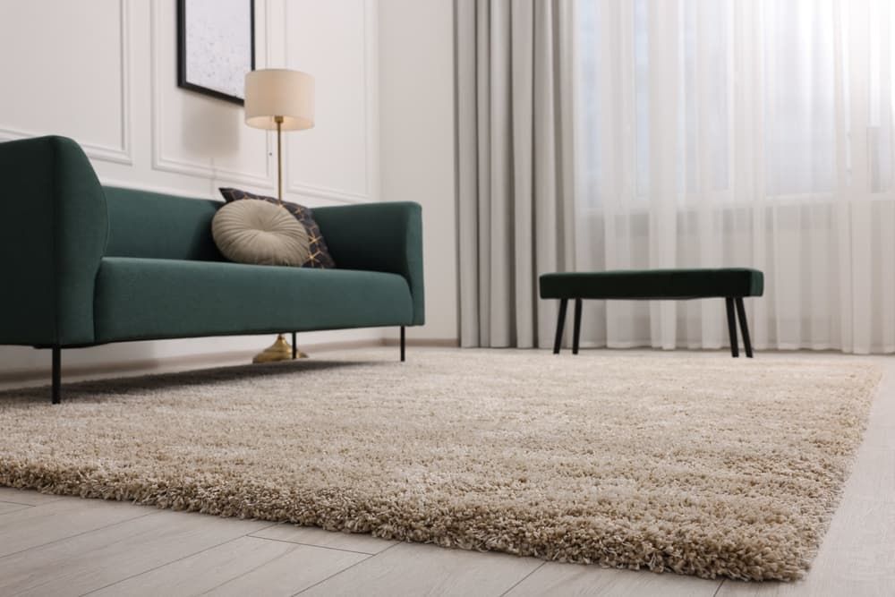 A Living Room With A Green Couch And A Rug   — Norm Evans Floors Pty Ltd in Noosa, QLD