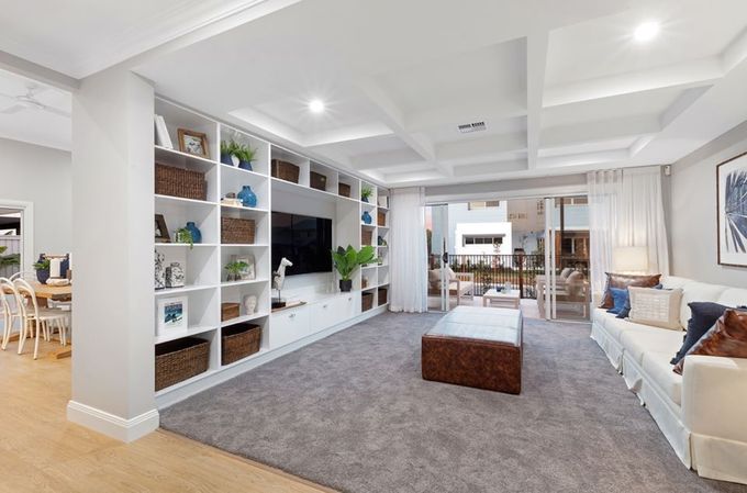 A Living Room With A Couch , Ottoman , Television And Shelves — Norm Evans Floors Pty Ltd in Kunda Park, QLD