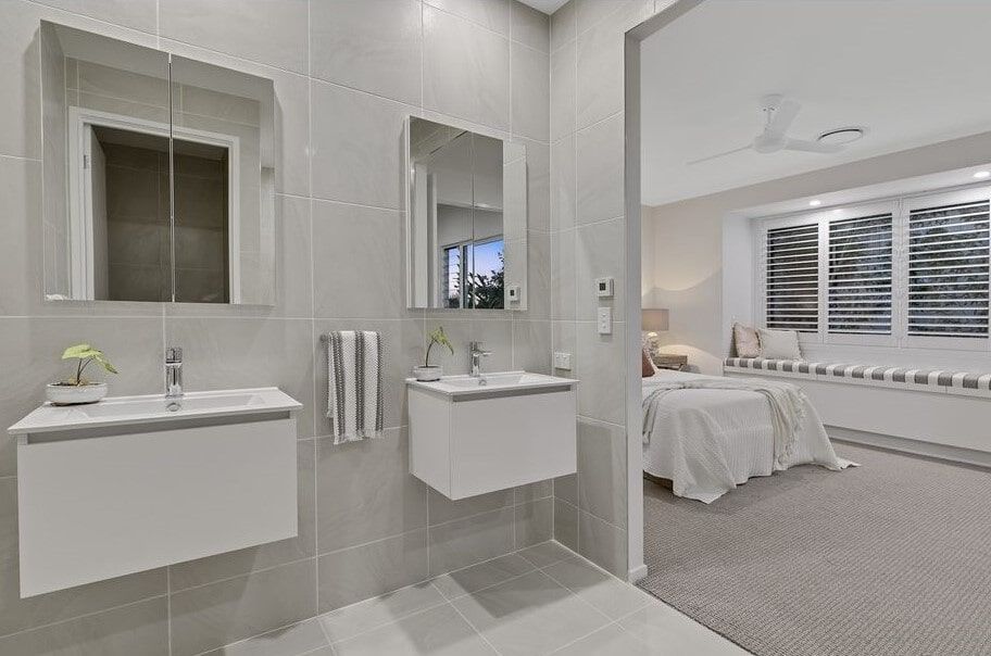 A Bathroom With Two Sinks And A Mirror Next To A Bedroom — Norm Evans Floors Pty Ltd in Kunda Park, QLD