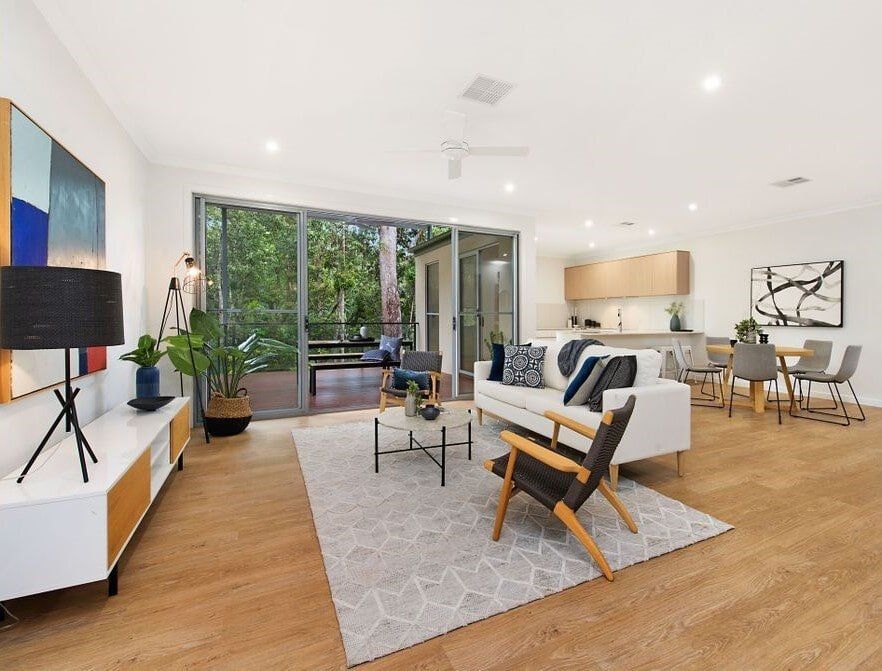 A Living Room With A Couch , Chair , Table And Rug — Norm Evans Floors Pty Ltd in Kunda Park, QLD
