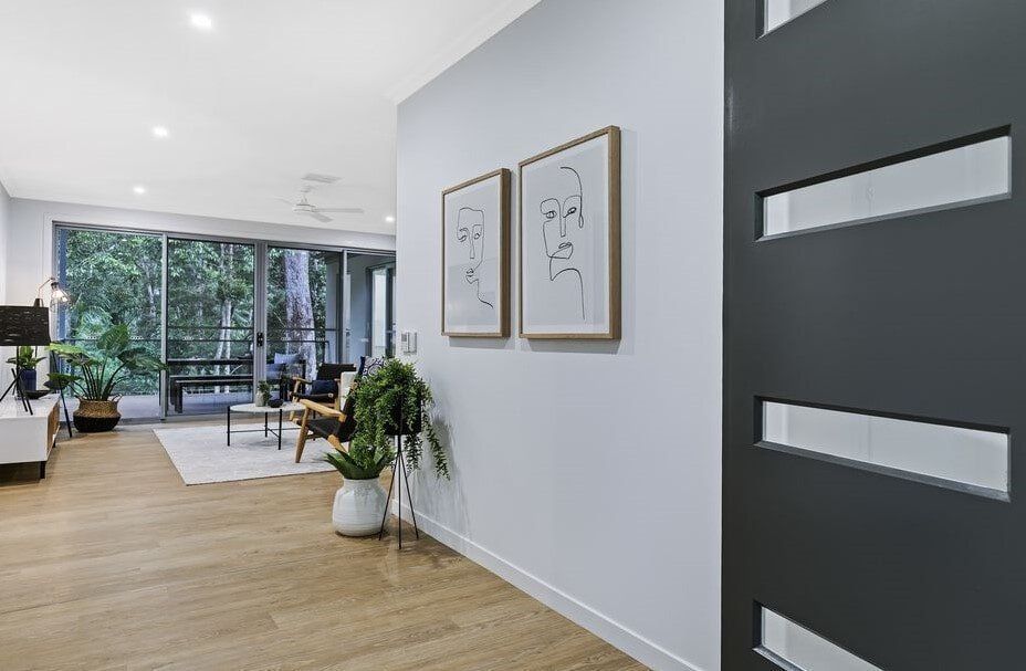 A Hallway In A House With A Black Door And Two Paintings On The Wall — Norm Evans Floors Pty Ltd in Kunda Park, QLD