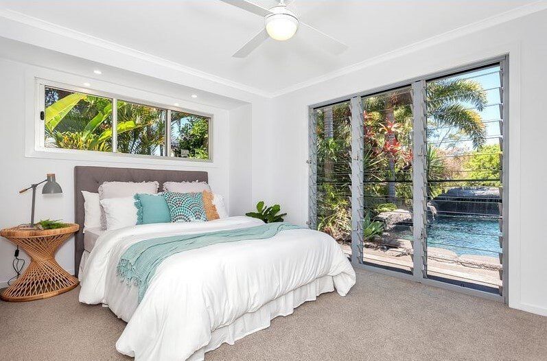 A Bedroom With A Large Bed And A Ceiling Fan — Norm Evans Floors Pty Ltd in Kunda Park, QLD