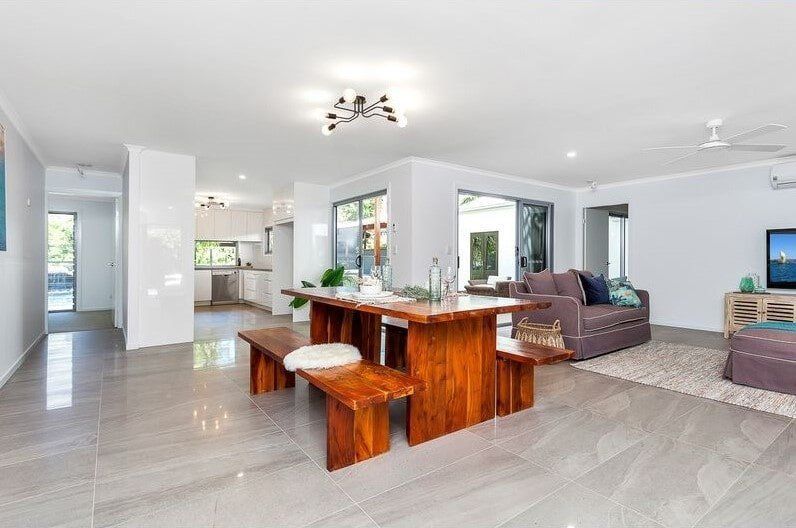 A Living Room With A Wooden Table And Benches And A Couch — Norm Evans Floors Pty Ltd in Kunda Park, QLD