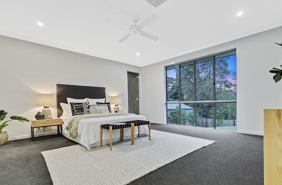 A Bedroom With A Large Bed And A Ceiling Fan — Norm Evans Floors Pty Ltd in Kunda Park, QLD
