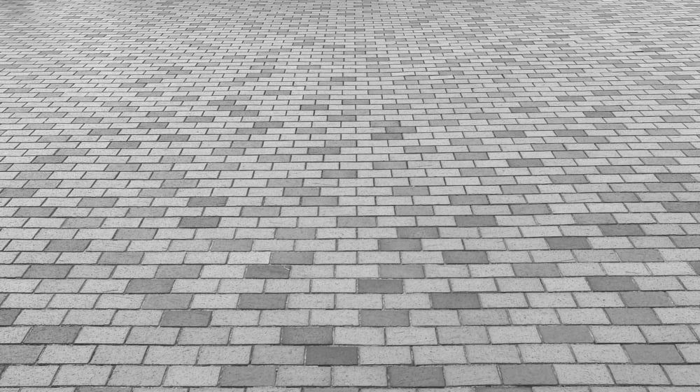 Brick paved ground, gray bricks arranged in a repeating pattern.