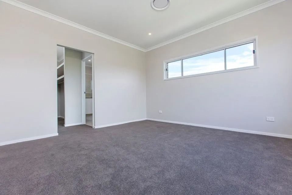 An Empty Bedroom With A Large Window And A Walk In Closet — Norm Evans Floors Pty Ltd in Kunda Park, QLD