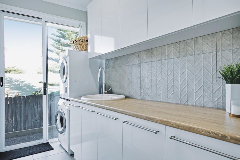 A Laundry Room With A Washer And Dryer , Sink , And Sliding Glass Doors — Norm Evans Floors Pty Ltd in Kunda Park, QLD