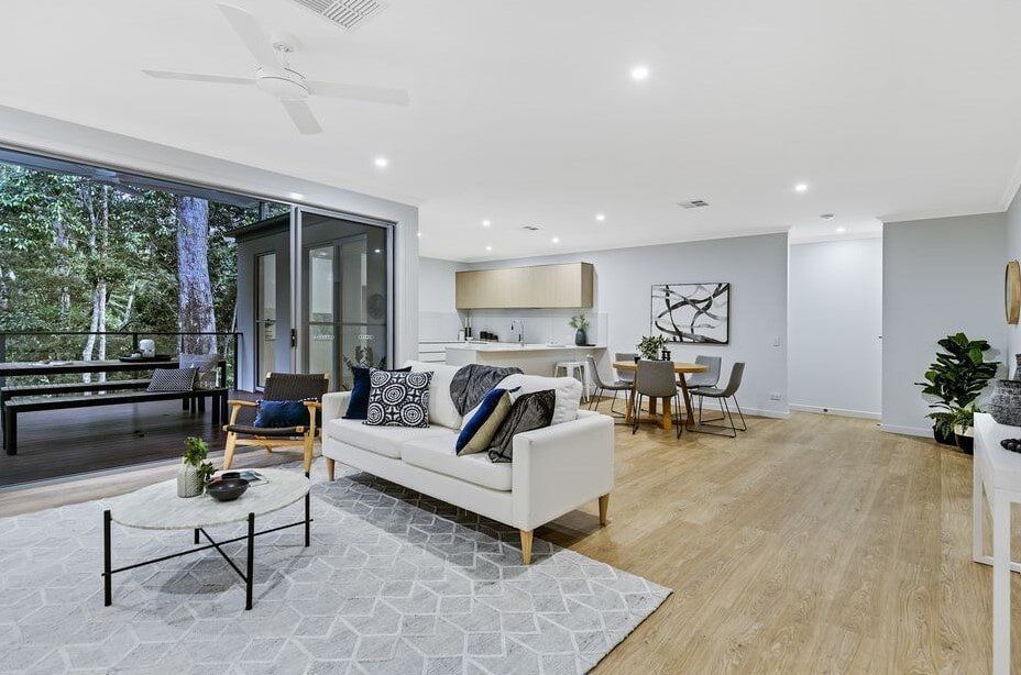 A Living Room With A Couch , Table , Chairs And A Ceiling Fan — Norm Evans Floors Pty Ltd in Kunda Park, QLD
