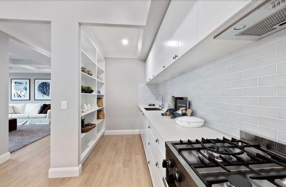 A Kitchen With White Cabinets And A Stove Top Oven — Norm Evans Floors Pty Ltd in Kunda Park, QLD