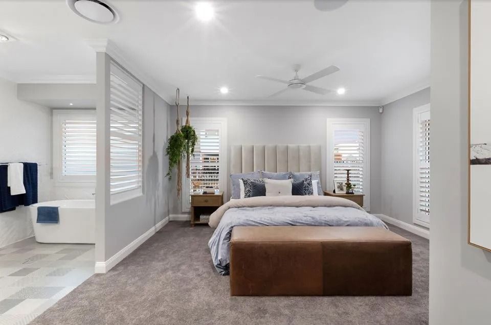 A Bedroom With A Large Bed And A Ceiling Fan — Norm Evans Floors Pty Ltd in Kunda Park, QLD