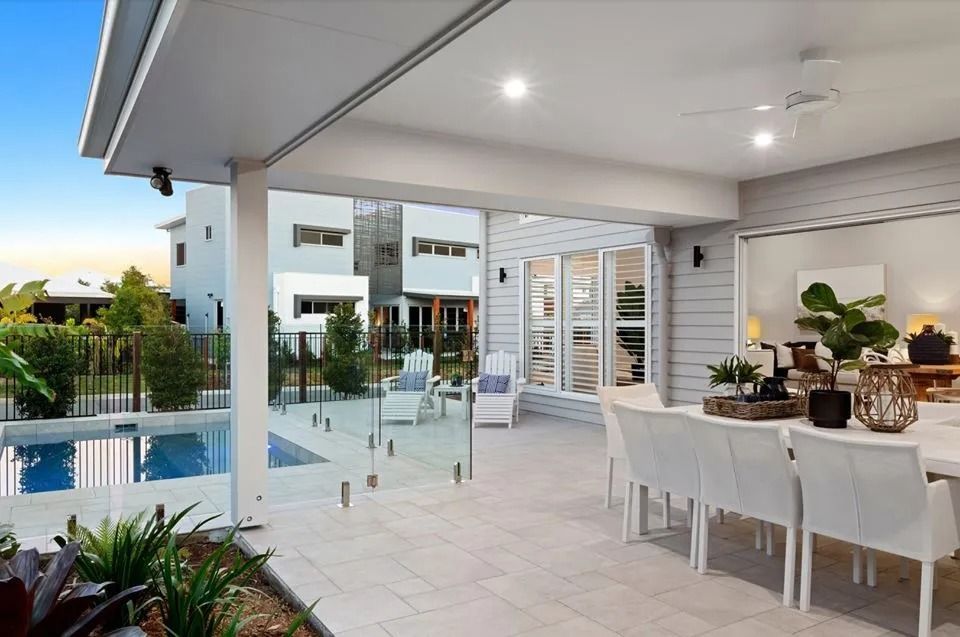 A Large Patio With A Dining Table And Chairs Next To A Pool — Norm Evans Floors Pty Ltd in Kunda Park, QLD
