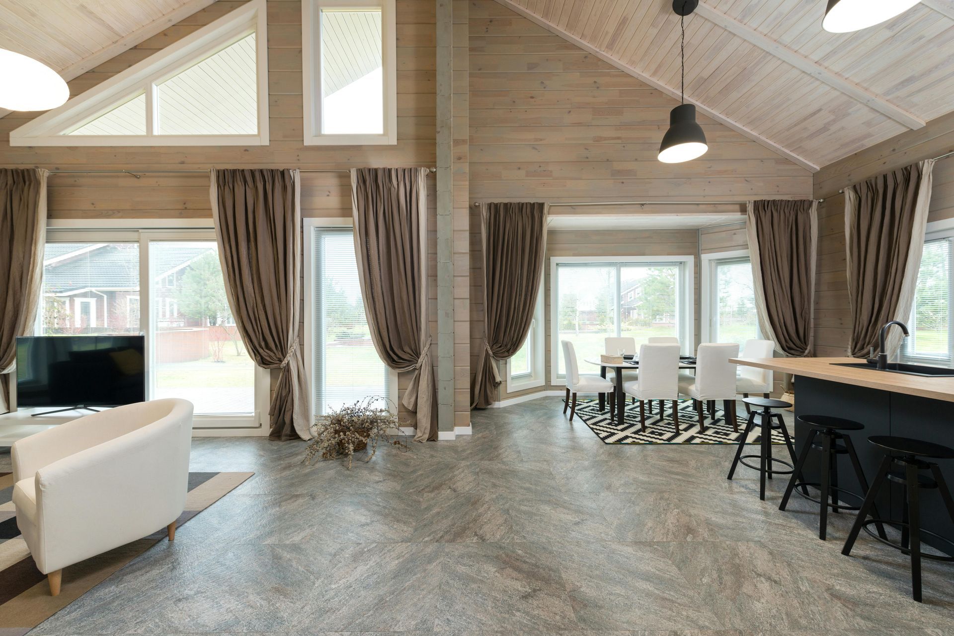 Hand peeling up a piece of vinyl plank flooring, showing its layers and texture.