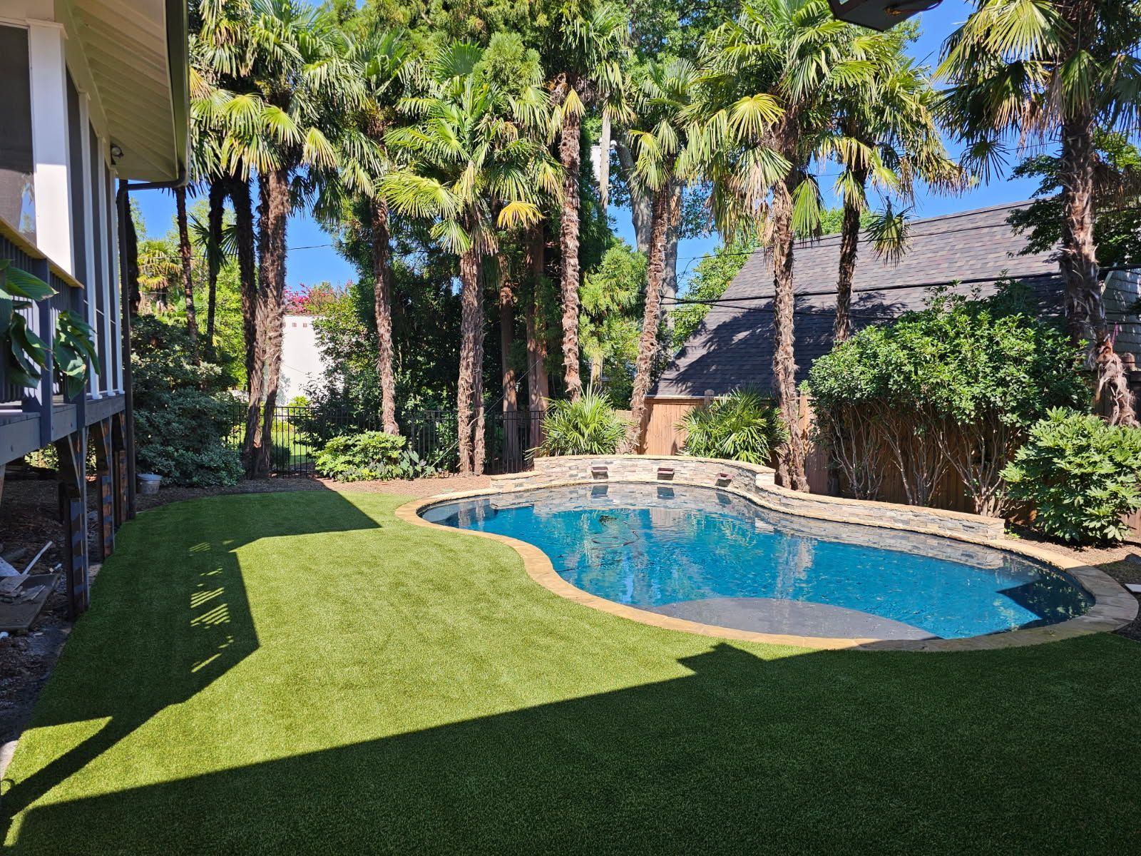 Pool surrounded by green turf