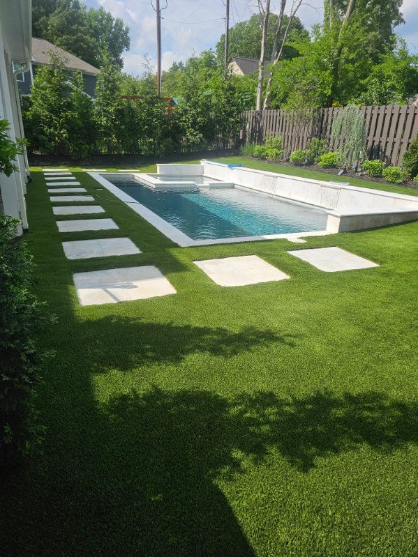 Rolled-up sod laid on a sports field, forming a narrow strip of turf over bare ground