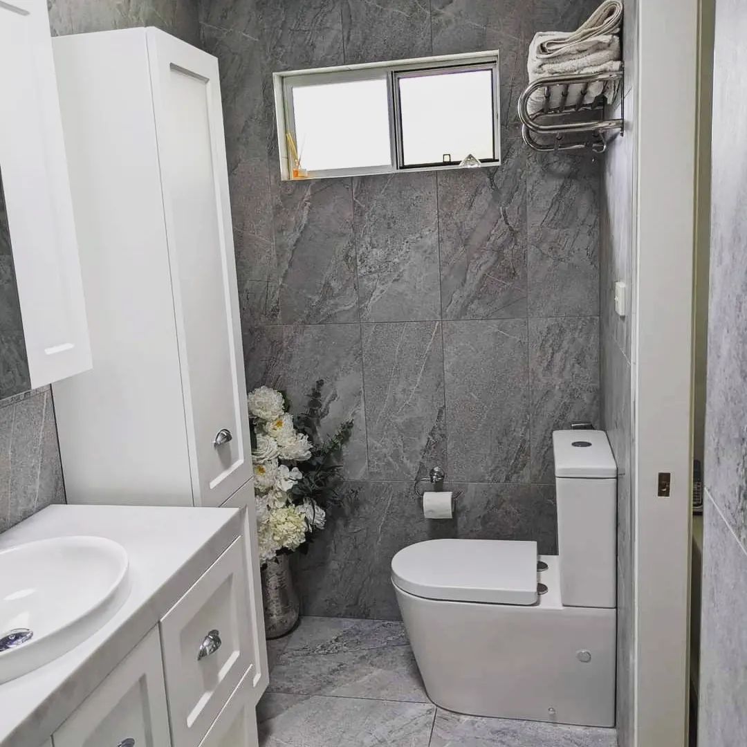A Modern Bathroom With Gray Tiled Walls, White Toilet, Vanity — Corrimal Discount Tiles and Bathroomwear in East Corrimal, NSW