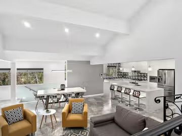 Modern open-plan living space with high ceilings, kitchen, dining table, and yellow armchairs — Corrimal Discount Tiles and Bathroomwear in East Corrimal, NSW