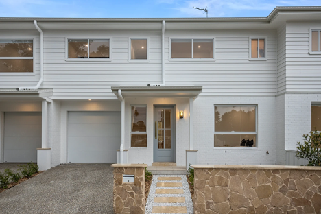 The Front of A White House with A Stone Wall and A Garage — Corrimal Discount Tiles and Bathroomwear in East Corrimal, NSW