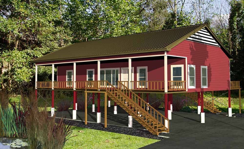 Red elevated house with wrap-around porch and stairs, in a wooded area.