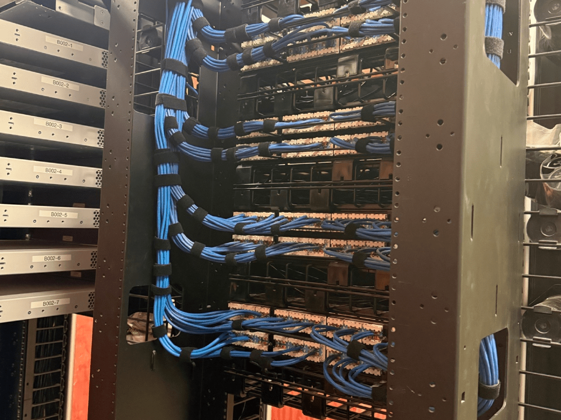 Server rack with blue network cables and densely packed equipment in a data center cabinet